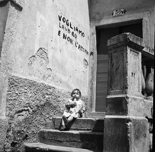 Hazel Kingsbury Strand Riva del Garda foto in bianco e nero di piccola bambina seduta per le scale con bambolina in mano