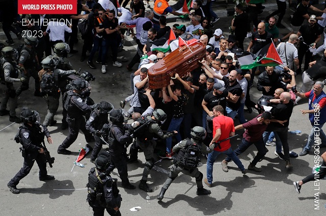 World Press Photo Bari foto a colori vista dall'alto di molte persone che tengono una bara aggredite dalla polizia