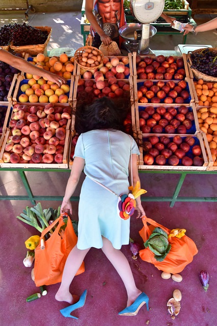 Sandro Giordano Roma foto a colori di donna a faccia in giu su banco di frutta con buste della spesa nelle mani