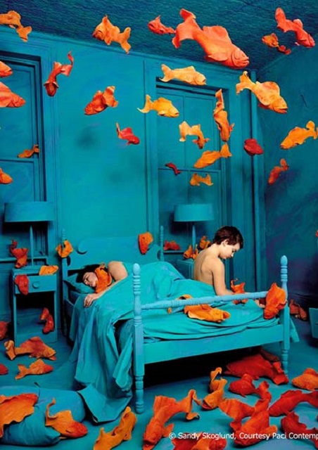 Sandy Skoglund Senigallia foto a colori di uomo e donna al letto in stanza dipinta di blu piena di pesci arancioni