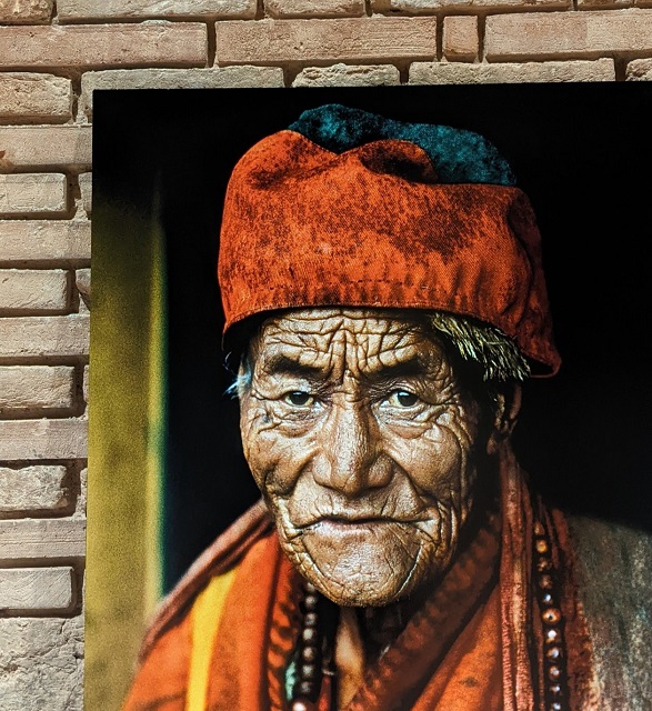 Steve McCurry Pisa primo piano a colori di anziano con cappello arancione