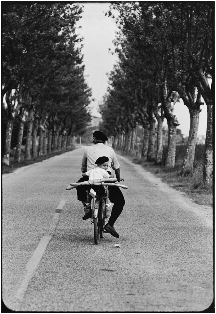 Elliot Erwitt Bari foto in bianco e nero di adulto e bambino in bicicletta con in mano due baguette
