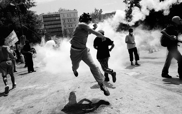 Gabriele Micalizzi Milano foto in bianco e nero di uomo che lancia fumogeno a manifestazione