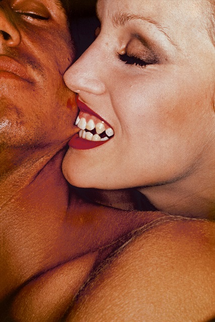 Helmut Newton Venezia foto a colori di donna che morde una guancia ad un uomo