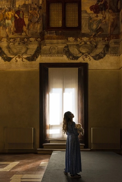 Alex Trusty Bologna bambina con orsacchiotto in mano che guarda soffitto di un museo