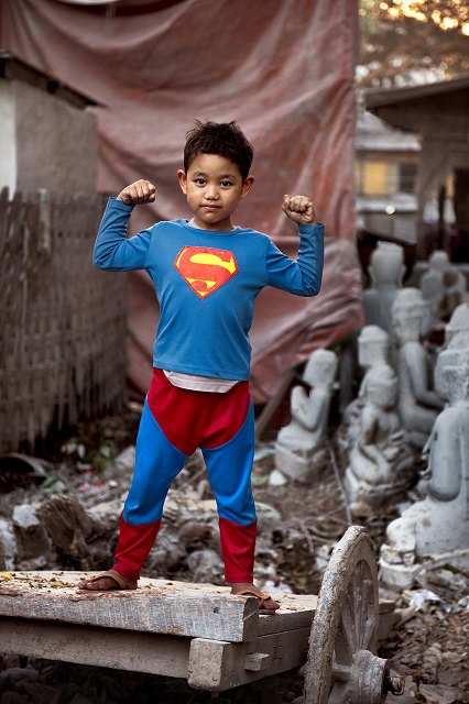 Steve McCurry Fermo Bambino vestito da Superman in mezzo alle macerie